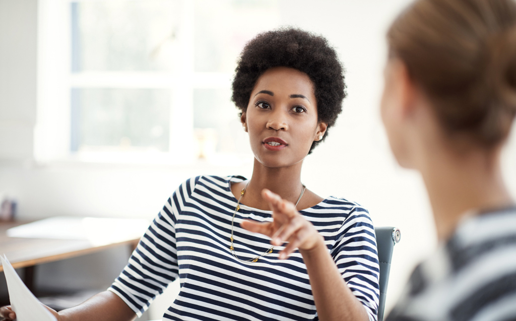 Two professionals having a discussion in an office.