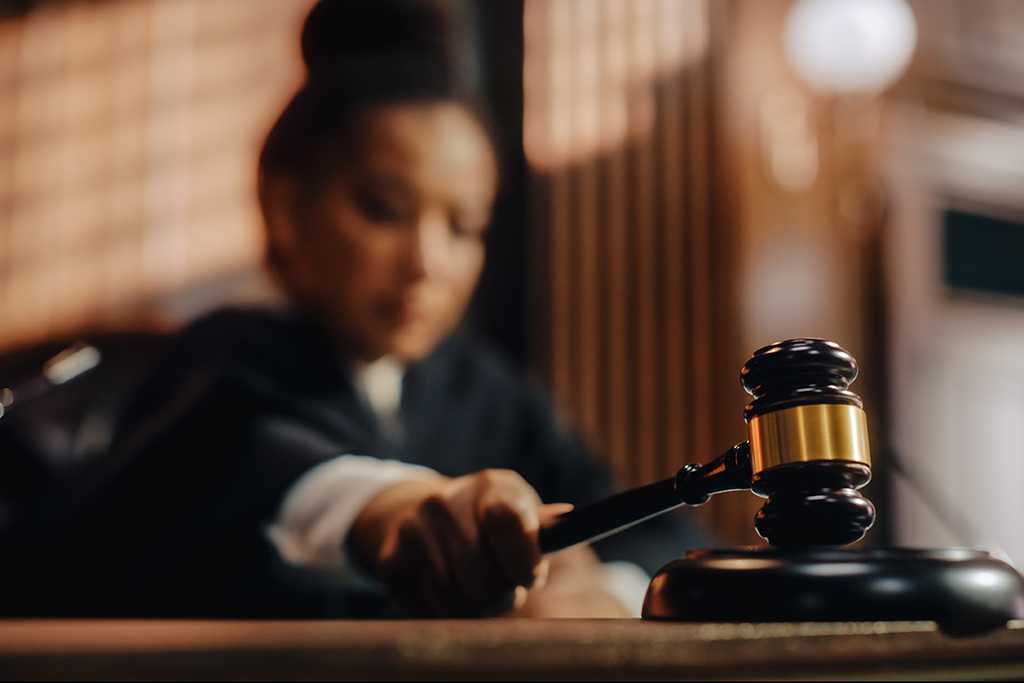 A woman judge striking gavel.