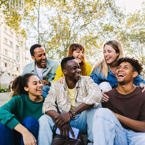 Group of older youth smiling at each other.