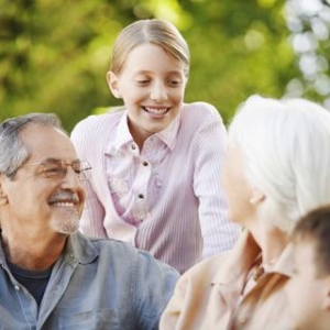 older adults outside with children smiling at one another