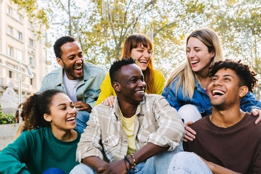 Group of older youth smiling at each other.