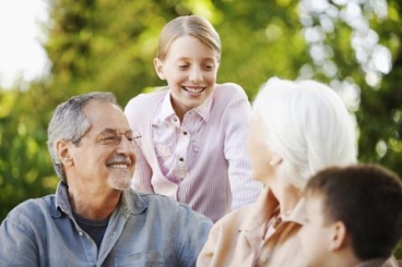 older adults outside with children smiling at one another