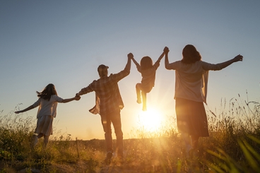 Hero image for webpage on prenatal alcohol exposure and FASDs, showing a family holding hands and jumping.