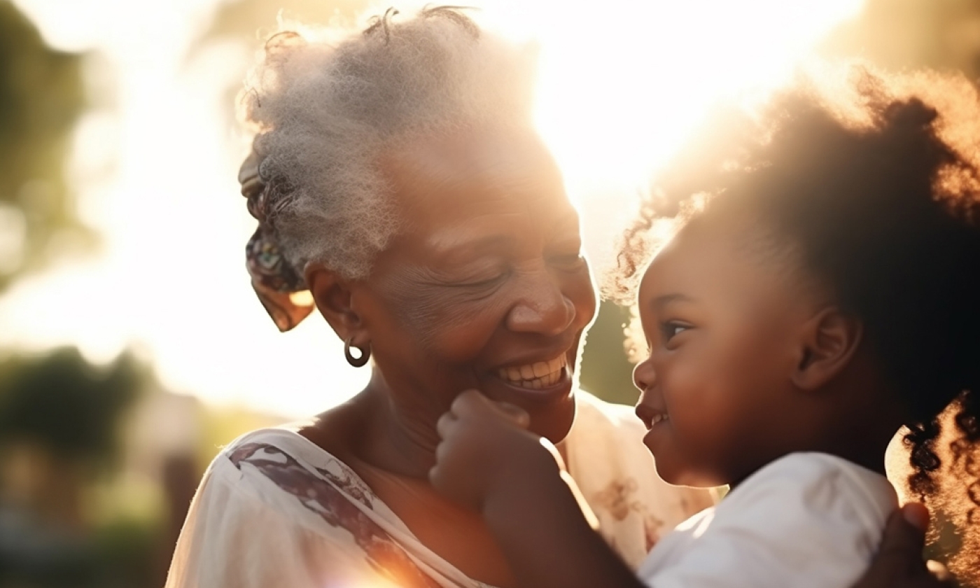 Black woman and young girl facing each other and smiling.