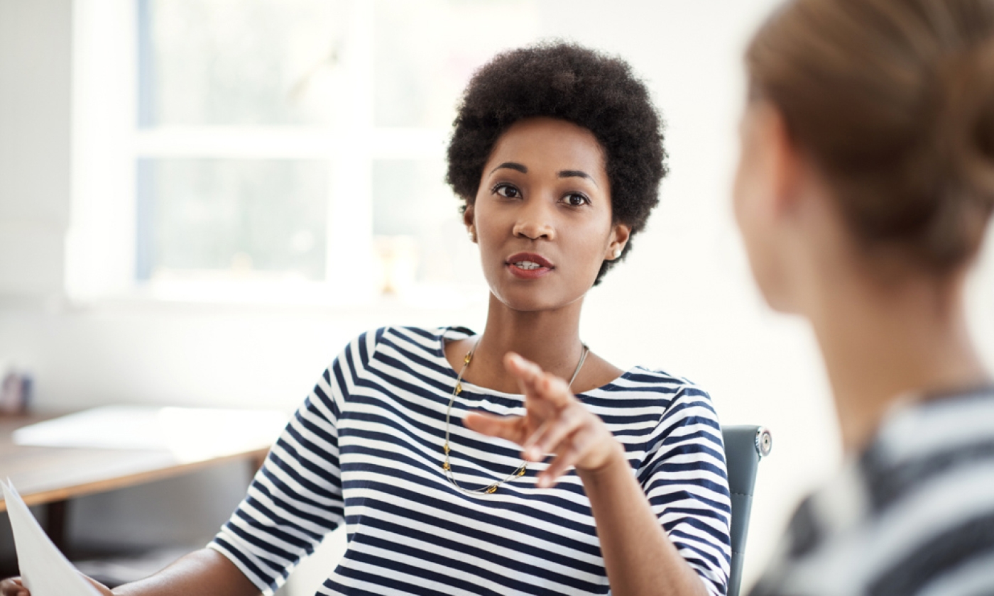 Two professionals having a discussion in an office.
