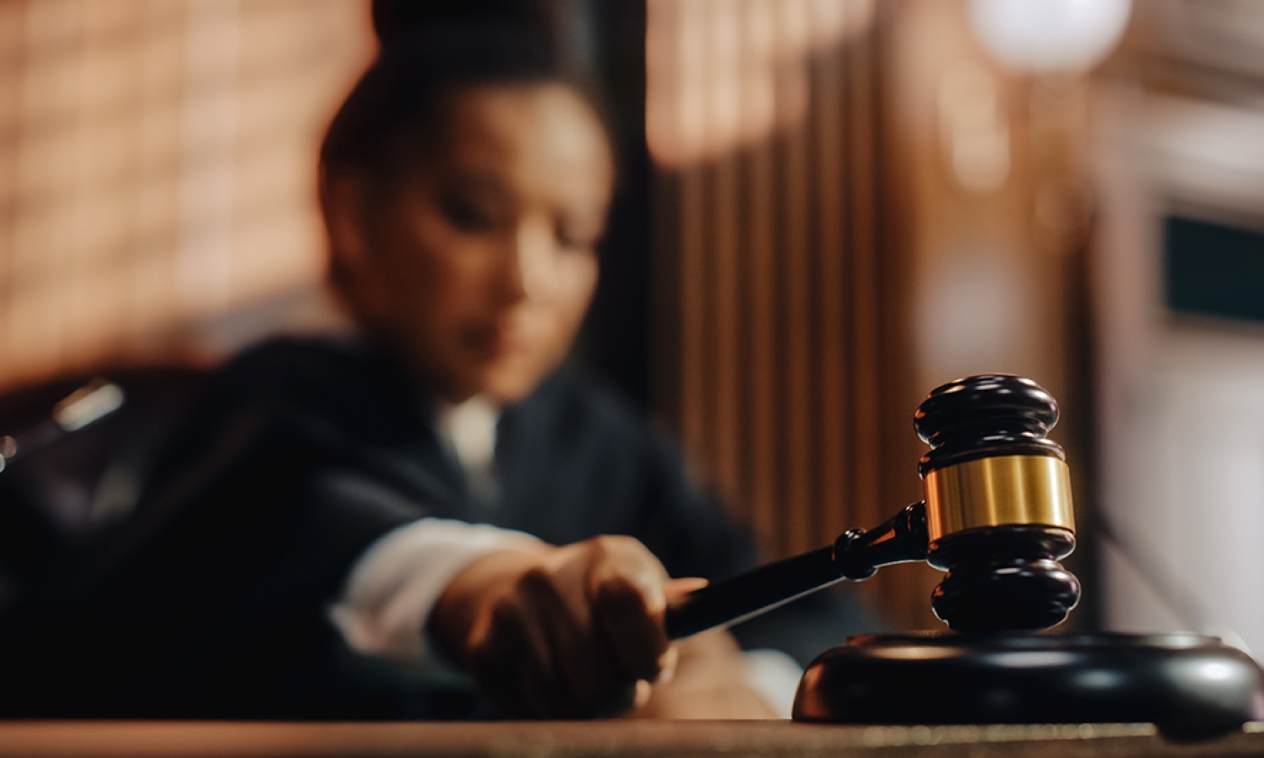 A woman judge striking gavel.