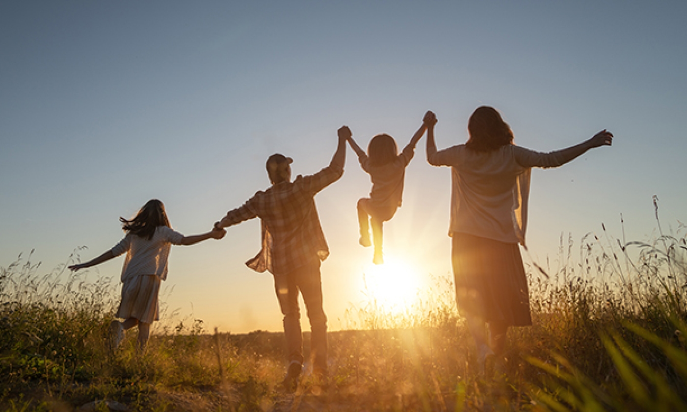 Hero image for webpage on prenatal alcohol exposure and FASDs, showing a family holding hands and jumping.